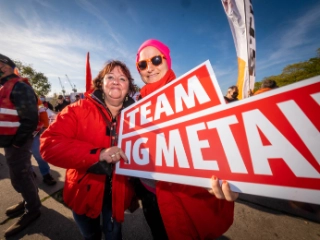 Zwei Metallerinnen mit Schild Team IG Metall in Hamburg beim Aktionstag Fairwandel.
